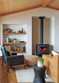 a living room filled with furniture and a fire place in the middle of it on top of a hard wood floor