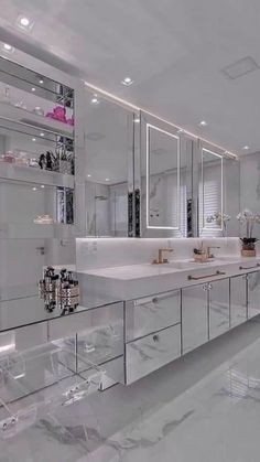 a large bathroom with white marble counter tops and mirrors on the wall, along with two sinks