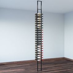 a tall wine rack in the corner of a room with wood floors and white walls