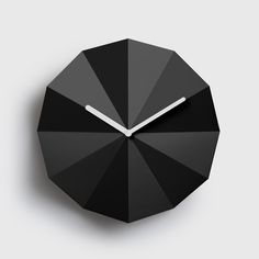 a black clock with white hands on a gray background