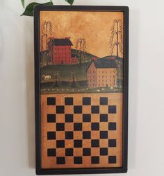 a painting on the wall with a checkerboard board and house in the background