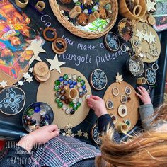 two children are playing with buttons and magnets on a blackboard that says, you make a garland pattern