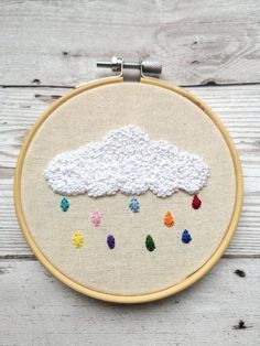 an embroidery project with white thread and multicolored rain drops