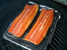 two salmons are being cooked on the grill