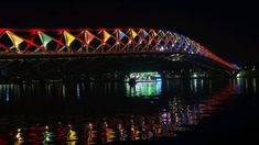 a colorful bridge lit up at night over water