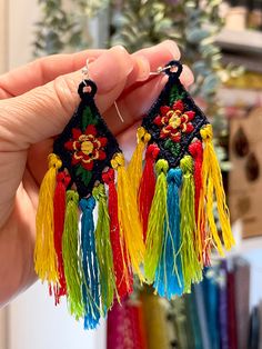 a pair of colorful tasseled earrings with flowers