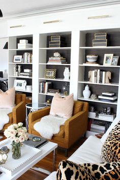 a living room filled with lots of furniture and bookshelves covered in leopard print