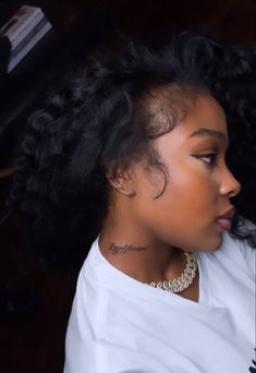 a close up of a person wearing a white shirt and black hair with tattoos on her neck