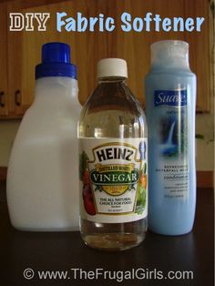 three bottles of vinegar, one blue and one white are on a kitchen counter top