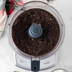 a food processor filled with dirt on top of a counter