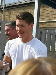 a man in white shirt talking to people