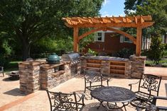 an outdoor kitchen with grill and seating area