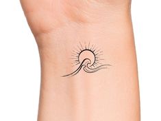 a woman's wrist with a small wave tattoo on the left side of her arm