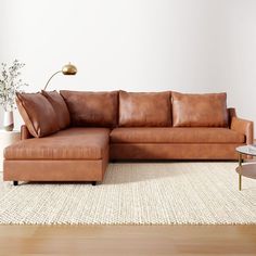 a brown leather couch sitting on top of a white rug