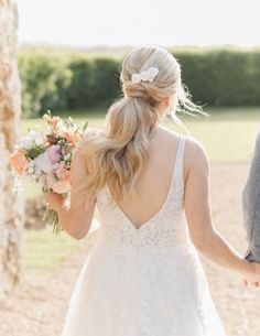 the bride and groom are holding hands