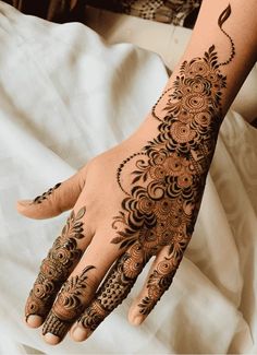 a woman's hand with henna tattoos on it