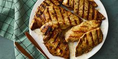 grilled chicken on a white plate with chopsticks and a green towel next to it