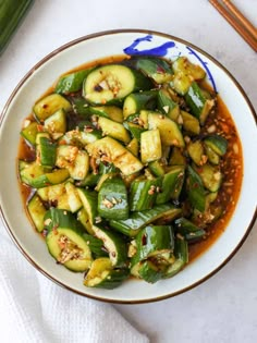 a white bowl filled with green vegetables and sauce