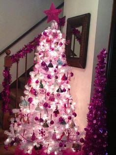 a white christmas tree with pink and purple decorations