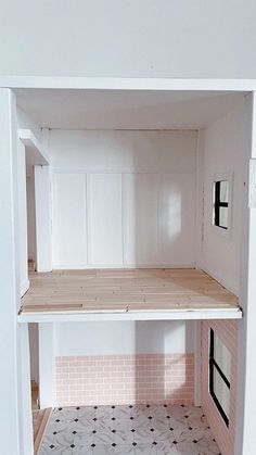 the inside of a doll house with all white walls and floors, including pink bricks