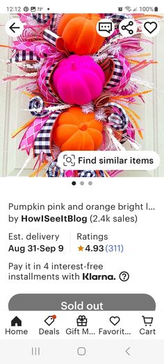 a pink and orange wreath with pumpkins on it