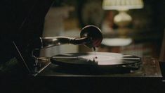 an old record player is playing music on the turntable with a lamp in the background