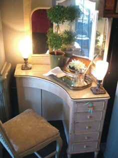 a desk with a mirror, chair and potted plant