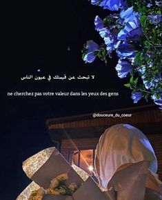 a person in a white veil is looking at some blue flowers and a lit candle