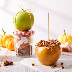 an apple sitting on top of a wooden table next to nuts and other food items