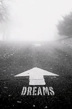 an arrow painted on the road that says dreams