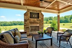 a covered patio with furniture and a fireplace