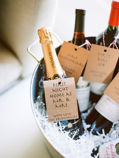 several bottles of wine in a bucket with some paper tags on the top and bottom