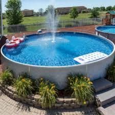 an aerial view of a swimming pool in the middle of a yard with water jets