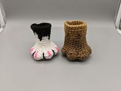 two small crocheted shoes sitting next to each other on top of a shelf