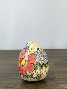 a painted egg sitting on top of a wooden table