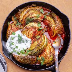 an iron skillet filled with artichokes, sour cream and seasoning