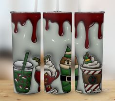 three christmas themed tumblers sitting on top of a wooden table