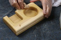 a person is making something out of a wooden block with their hands on the handle