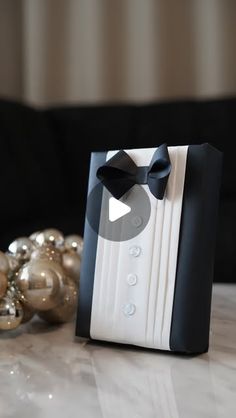 a black and white photo frame sitting on top of a table next to christmas ornaments