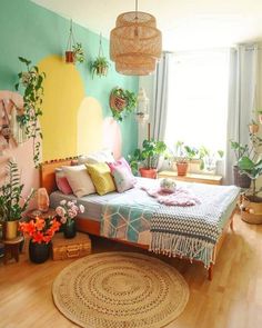 a bedroom decorated in pastel colors with potted plants