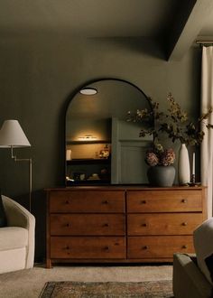 a living room scene with focus on the dresser and large mirror over it's top