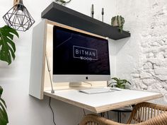 a desktop computer sitting on top of a wooden desk next to a wicker chair