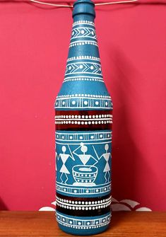 a blue and white vase sitting on top of a wooden table next to a red wall