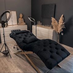 a black chaise lounge chair sitting on top of a hard wood floor