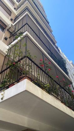 an apartment building with flowers growing on the balconies