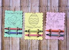 three easter cards hanging on a line with crayons