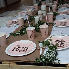 the table is set up with pink cups and place settings for guests to sit at