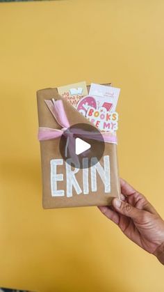 someone holding up a brown bag with the word erin on it