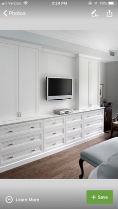 a bedroom with white cabinets and a flat screen tv on the wall, along with a bed