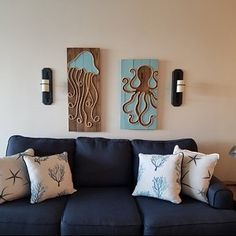 a living room filled with blue couches and two wall mounted octopus art on the walls